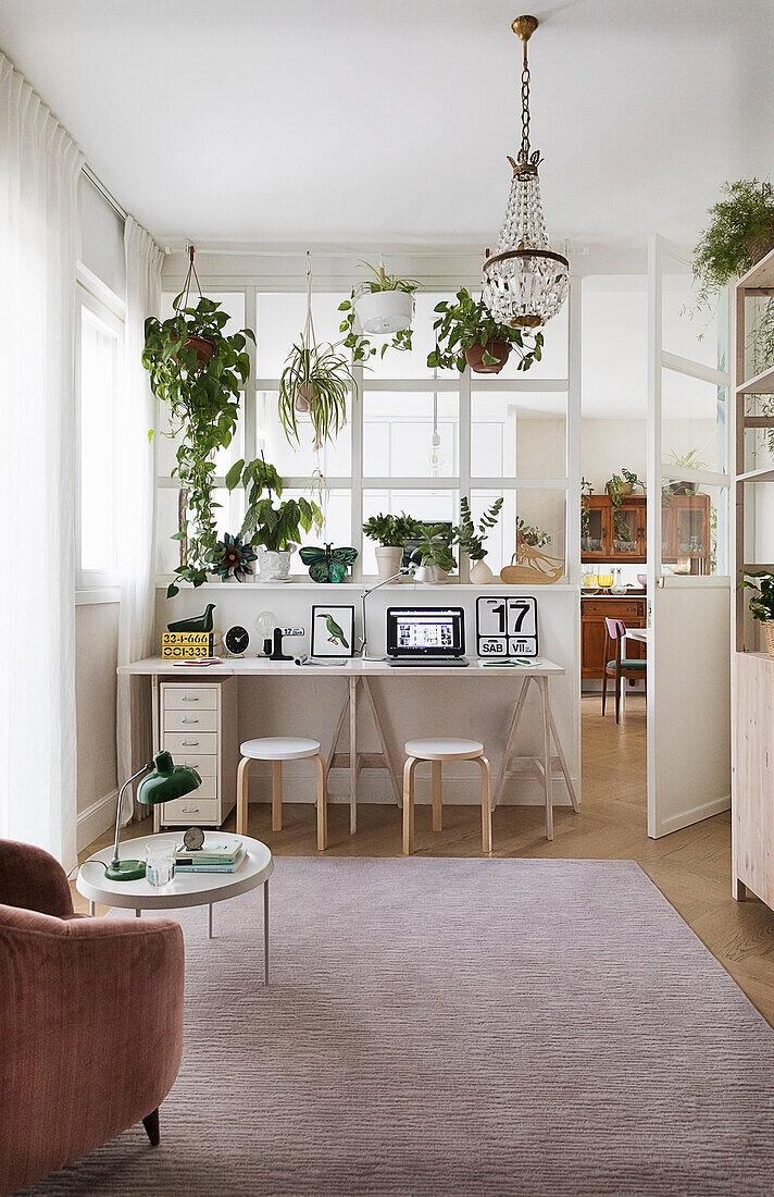 View from the reading place to the desk and indoor plants in front of the glass partition wall