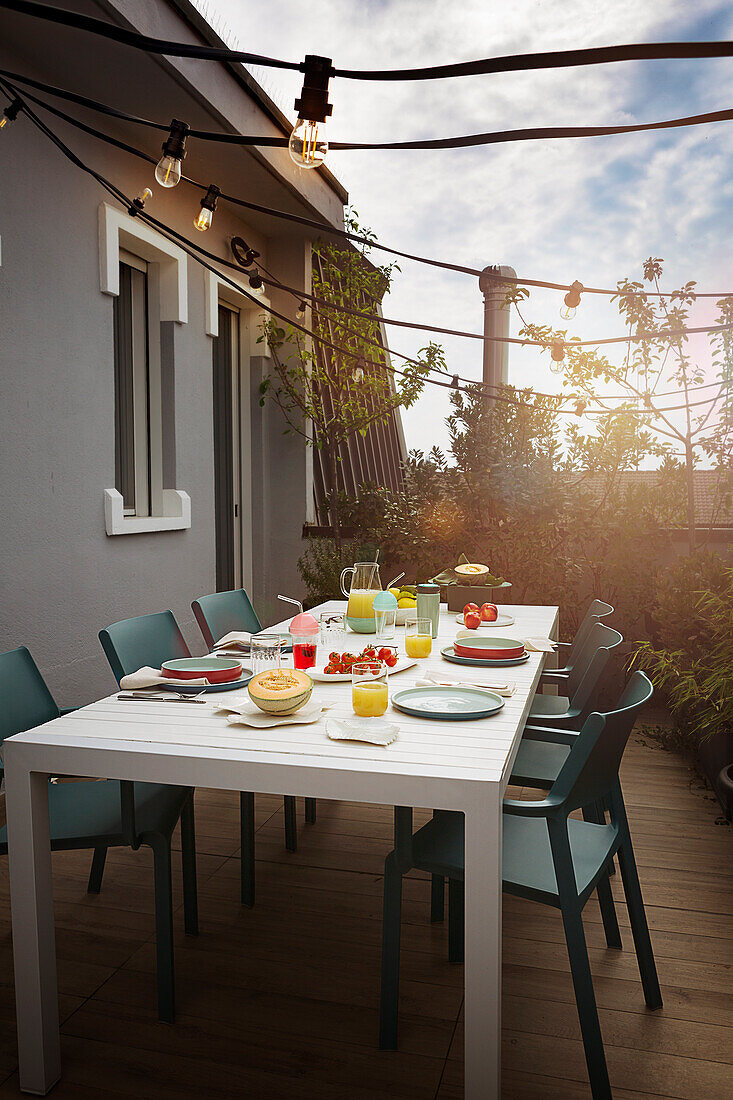 Gedeckter Tisch mit Stühlen auf der Terrasse