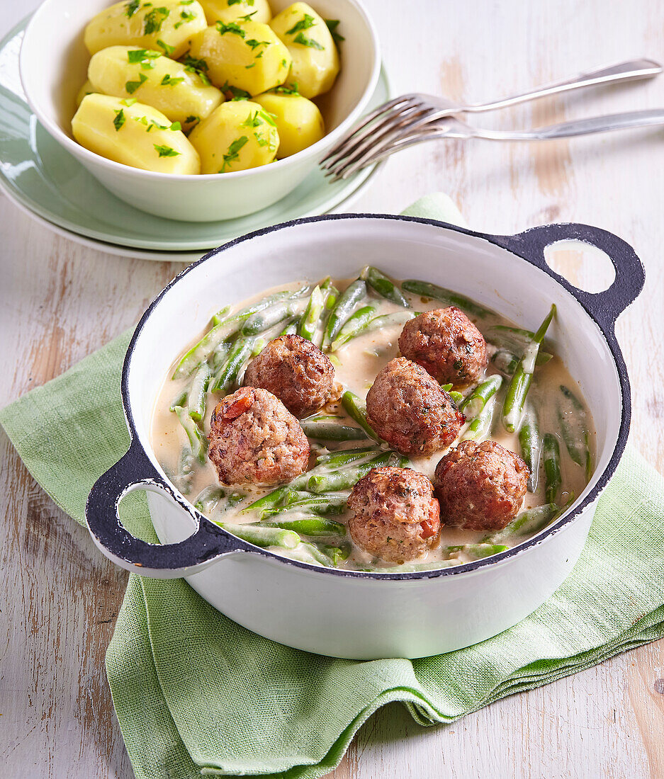 Bean pods (legumes) in cream sauce with meatballs