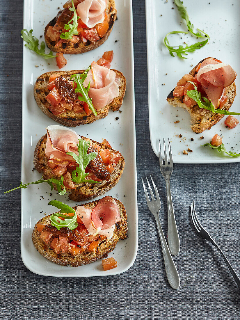 Bruschetta mit Parmaschinken, Tomaten und Rucola