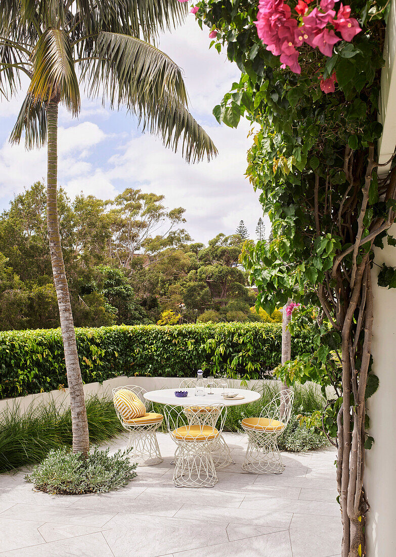 Bistro Table with chairs on a terrace with palm tree