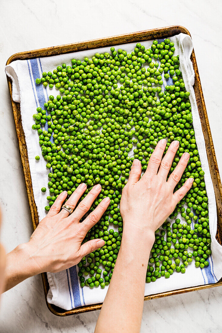 Spreading blanched green peas on a cloth