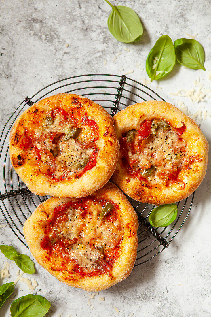 Pizzette (Minipizzen) mit Käse, Tomaten, italienischem Schinken und Chili