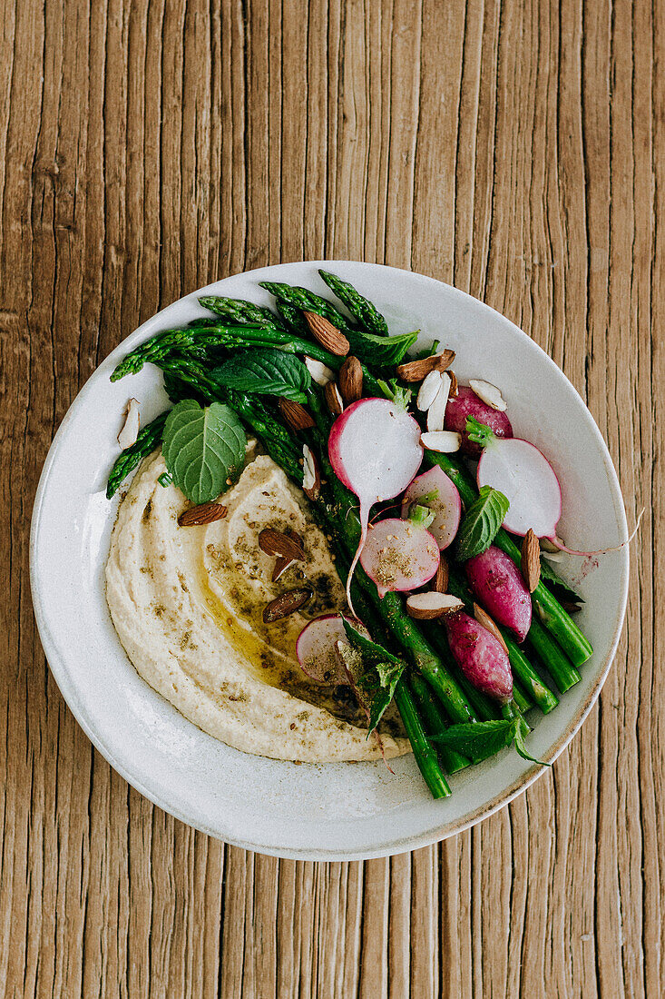 Hummus bowl with asparagus and radishes