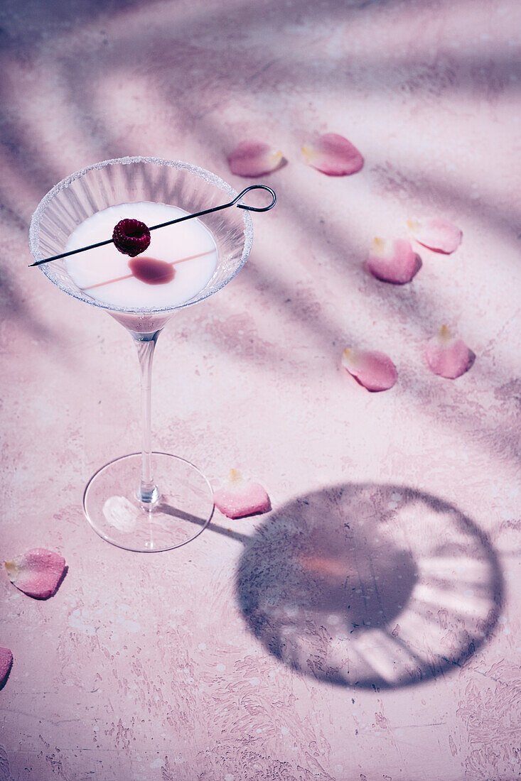 Himbeerlikör im Glas auf rosa Untergrund