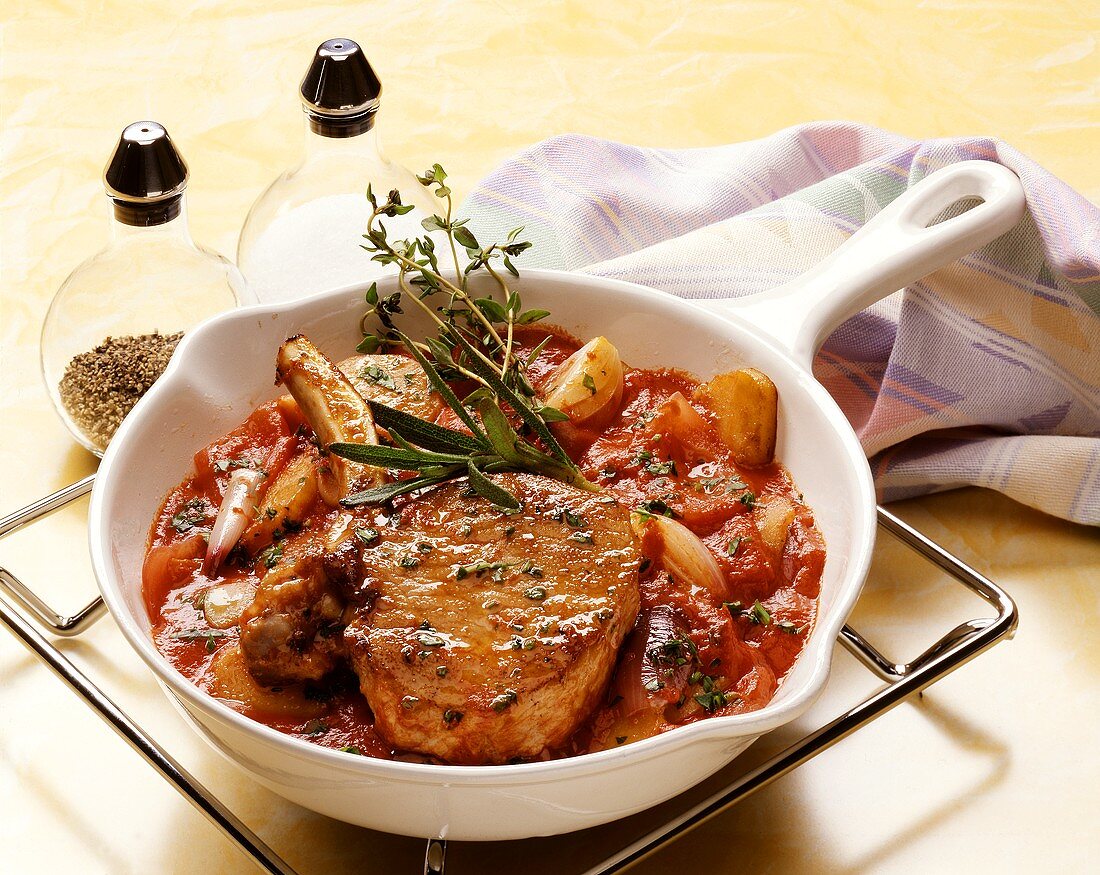 Veal cutlet on tomato sauce in white china pan
