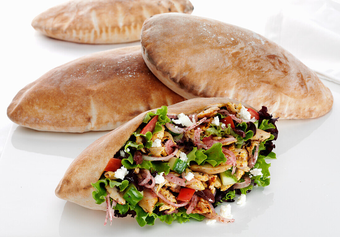 Pita pocket stuffed with Mediterranean spiced chicken, salad greens, cucumber, tomatoes, sumac onions, feta cheese and black olives