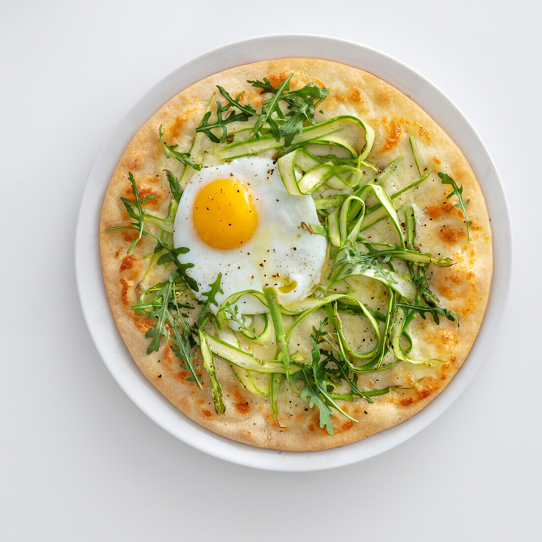 Pizza Bianca mit grünem Spargel und Spiegelei