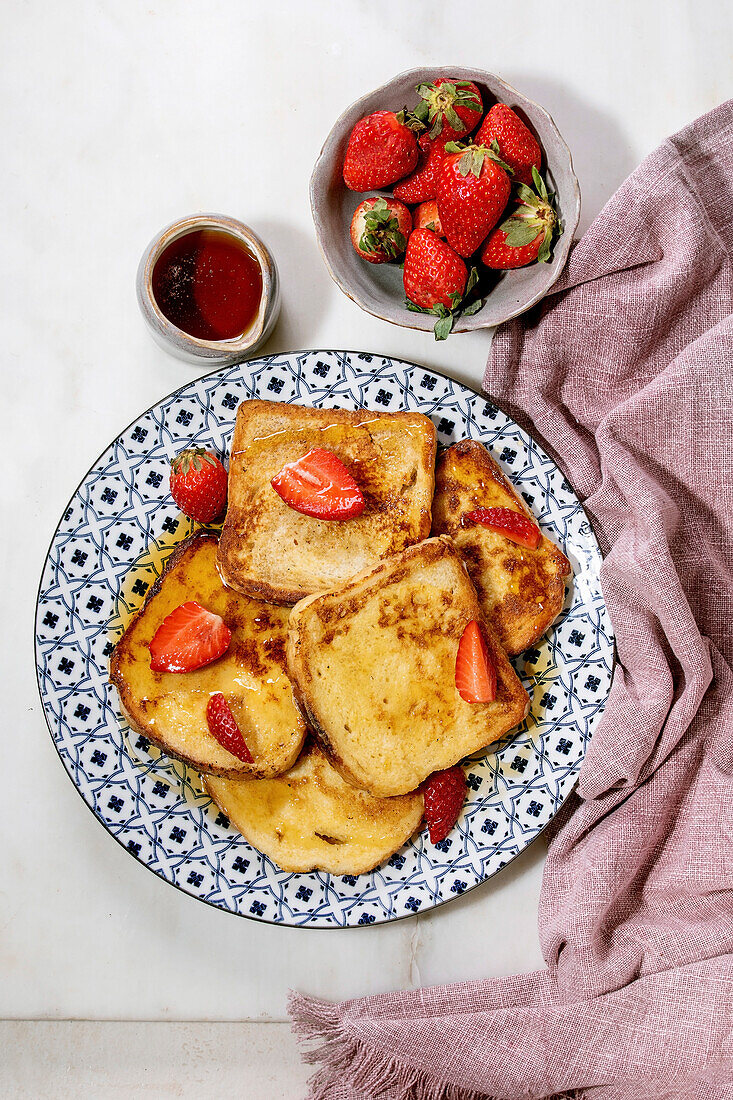 French toasts with fresh strawberries and maple syrup