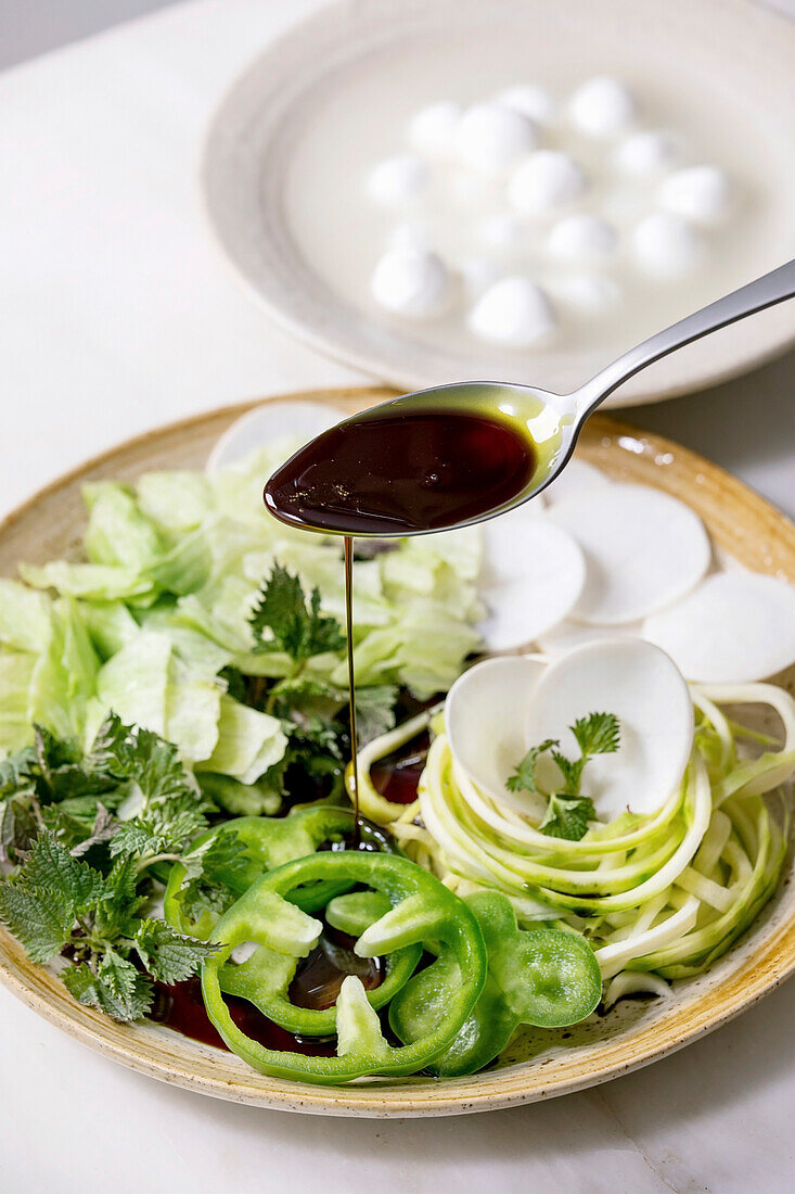 Green salad with zucchini spaghetti, vegetables and pumpkin seed oil