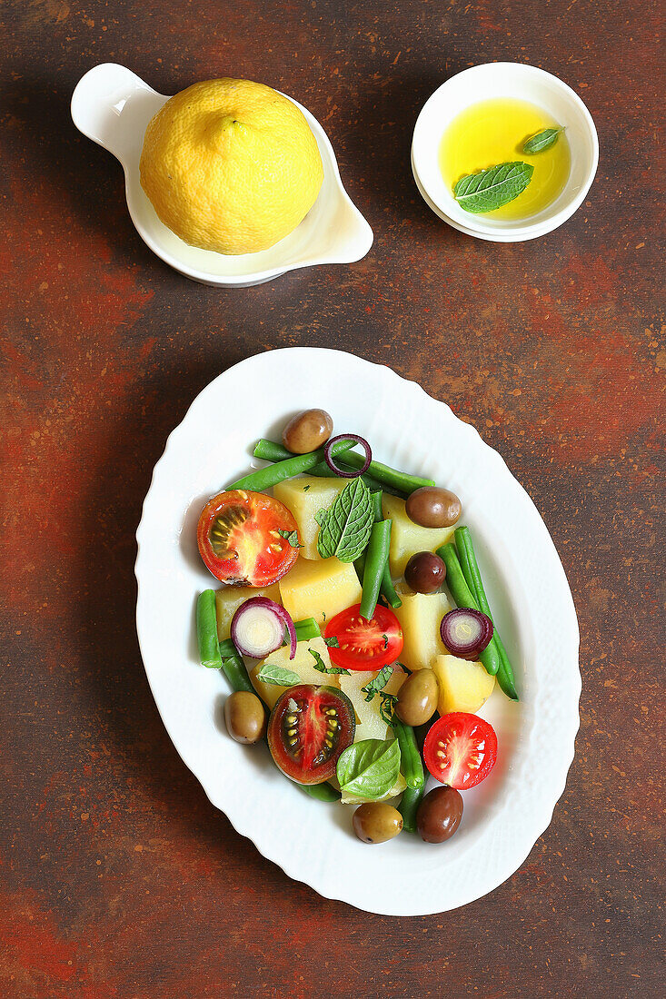 Potato salad with green beans, olives and tomatoes