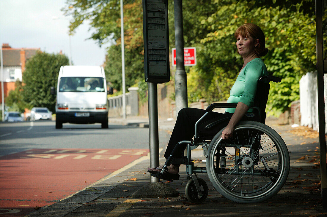 Woman in a wheelchair waiting for a bus