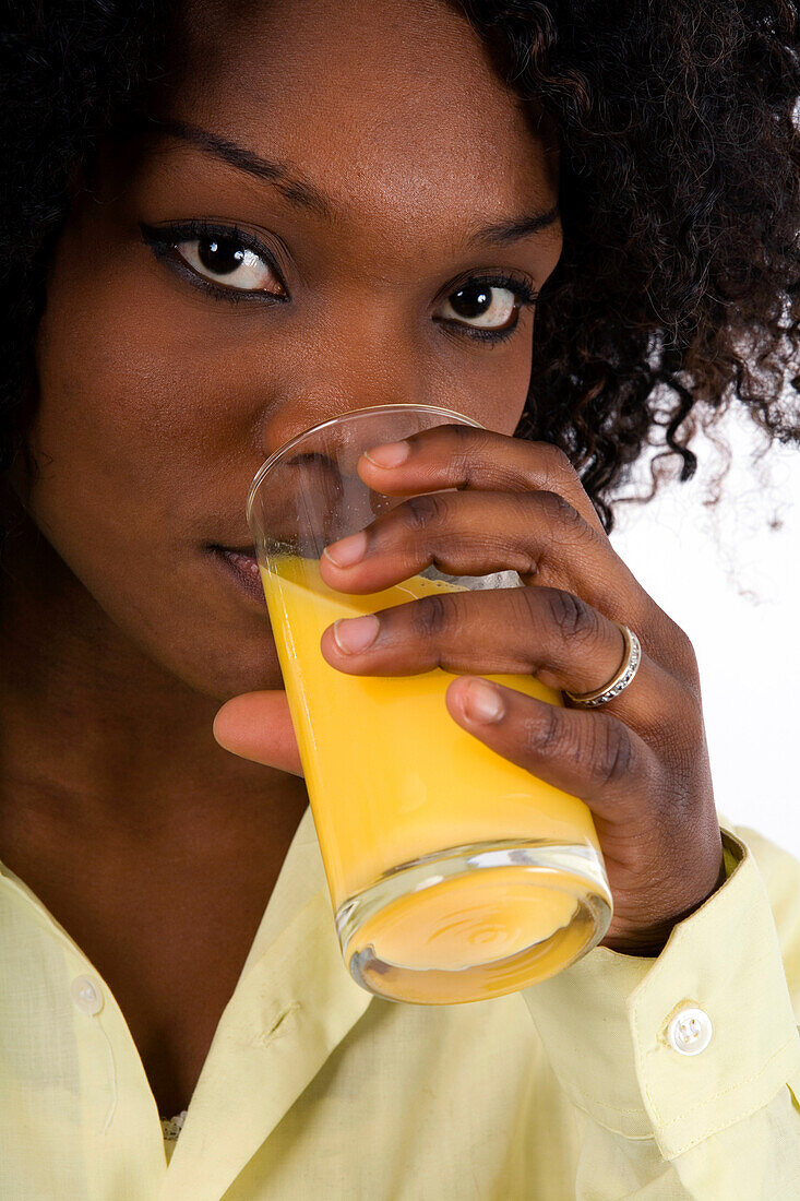 Young woman drinking a glass of orange juice