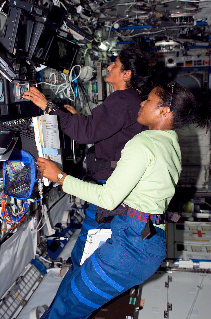 Astronauts working controls of Canadarm2