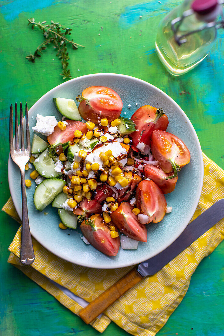 Cucumber and tomato salad with sweetcorn, olives and feta