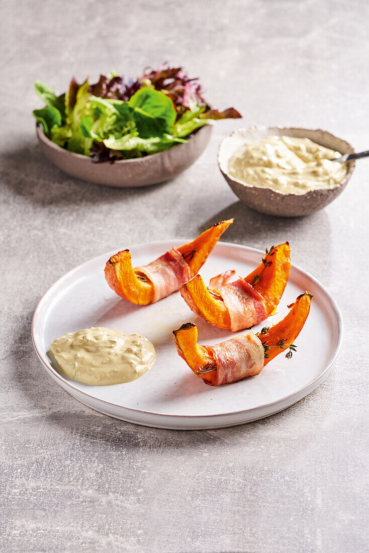 Pumpkin wedges with bacon and a dip