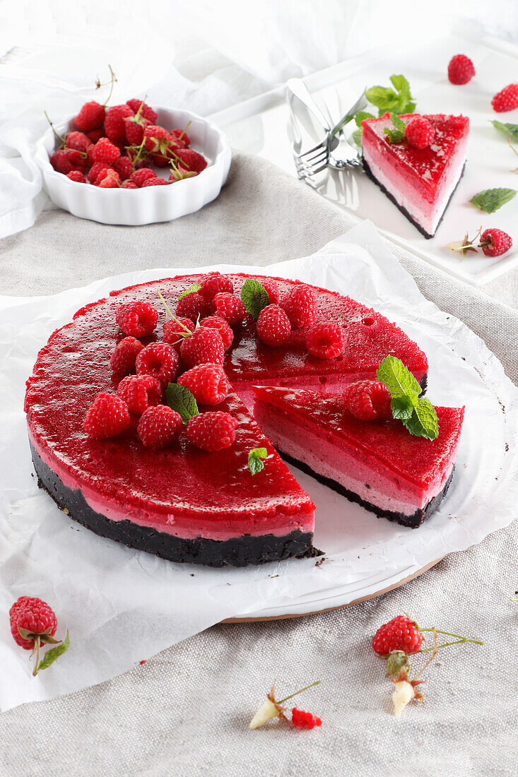Ombre cheesecake with raspberries on a chocolate biscuit base
