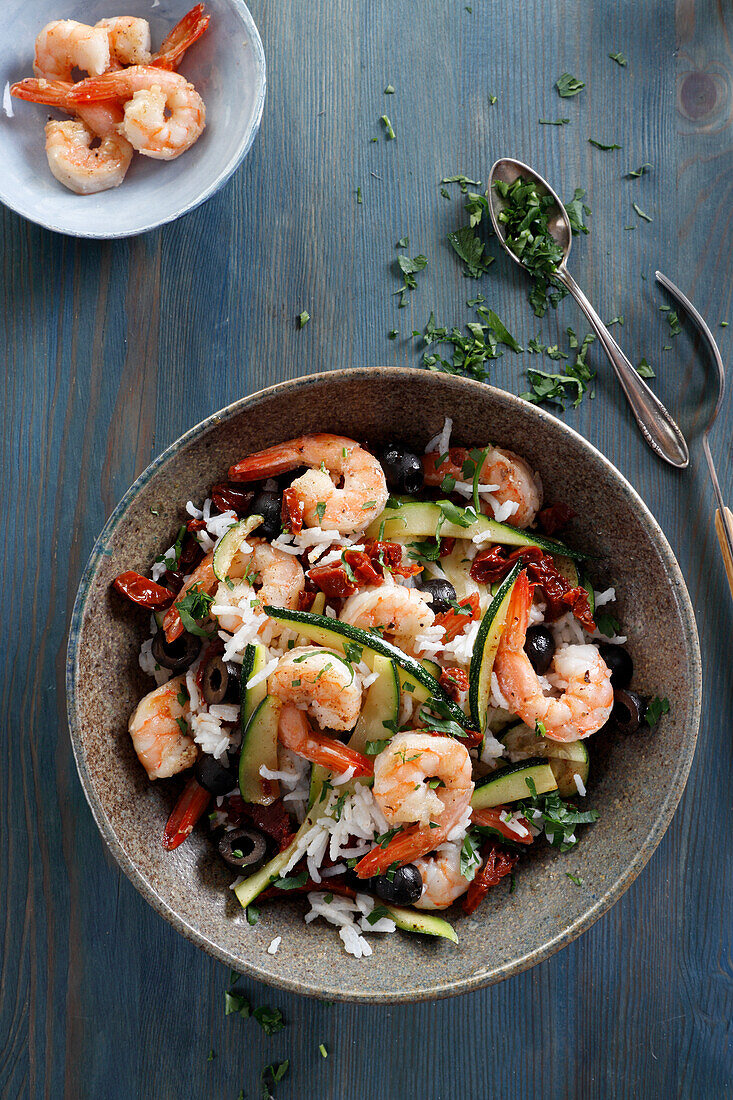 Dish with shrimps, rice, olives and zucchini