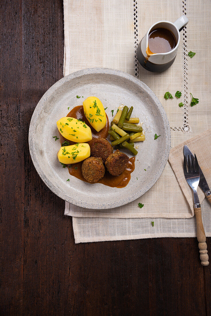 Vegane Falafel mit Kartoffeln, gelben und grünen Bohnen und Sauce