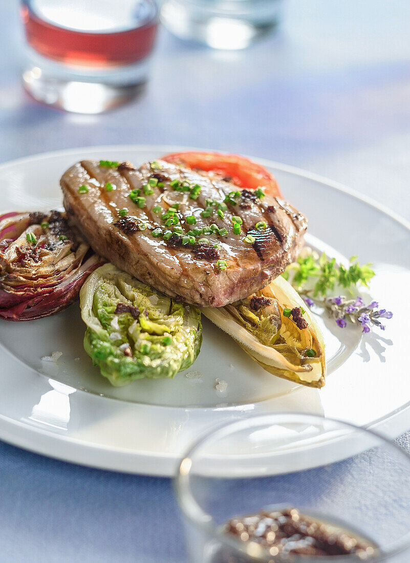 Pork steak on grilled salad hearts