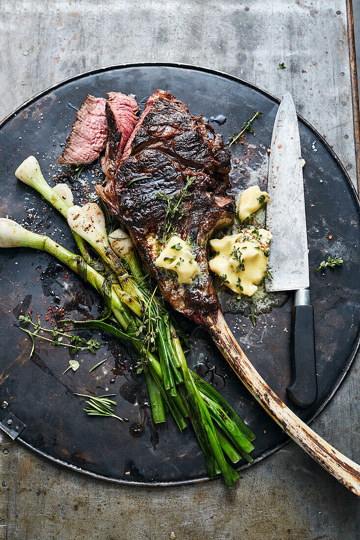 Gegrilltes Tomahawk-Steak mit Frühlingszwiebeln und Chili-Kräuter-Butter