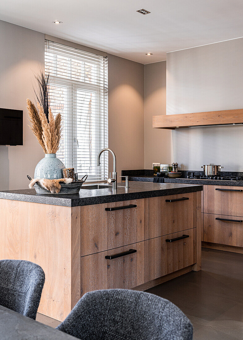 Custom kitchen in rustic oak with blue iron handles and granite countertop