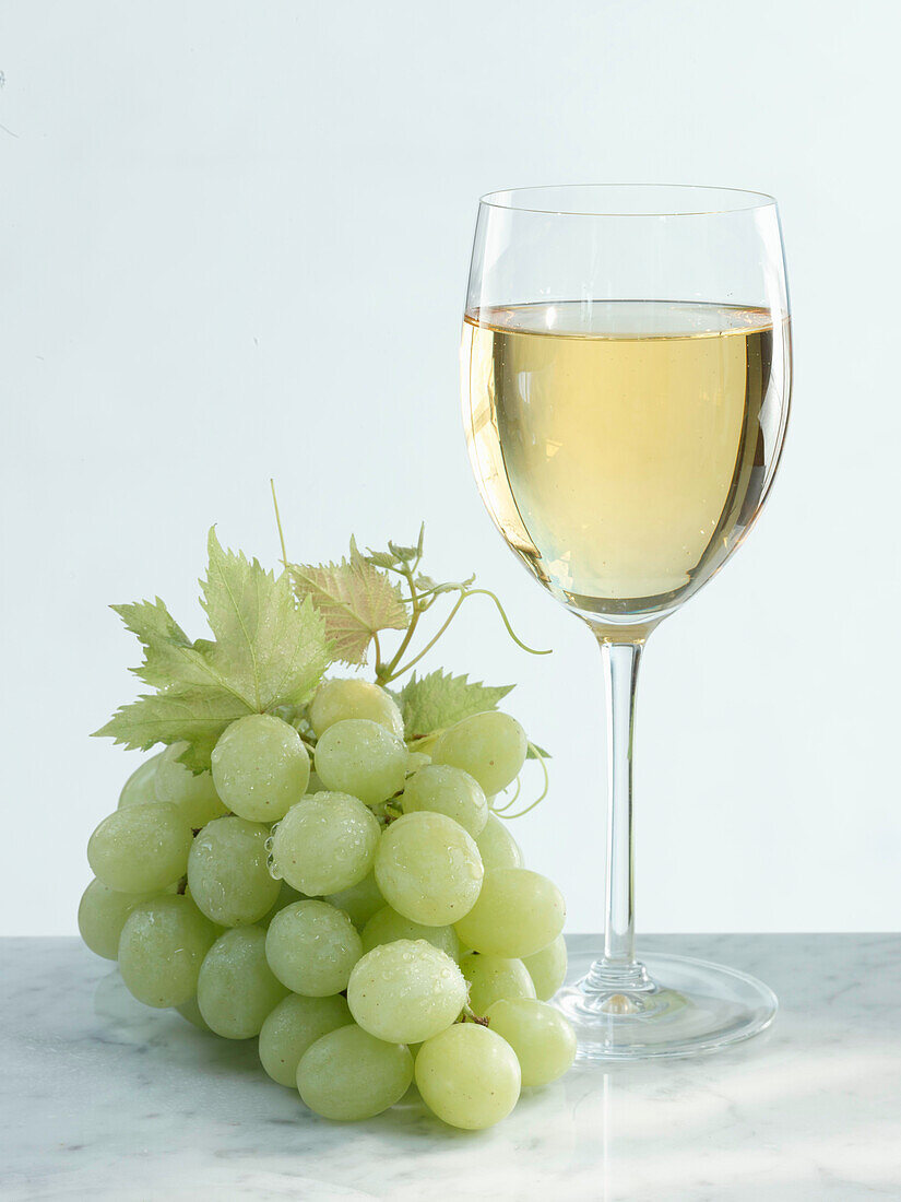 Glass of white wine with grapes