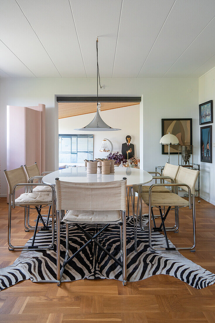 Oval dining table with classic chairs on zebra skin rug in dining room