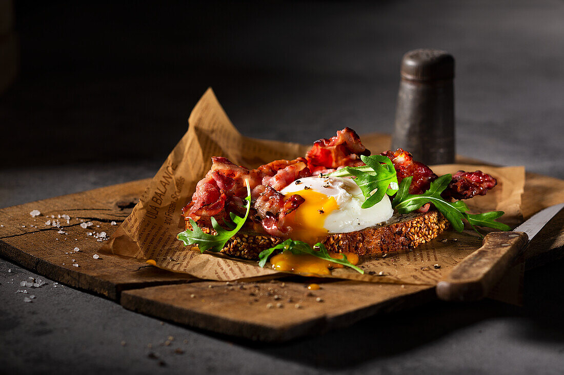 Three-grain bread with bacon, a poached egg and rocket salad