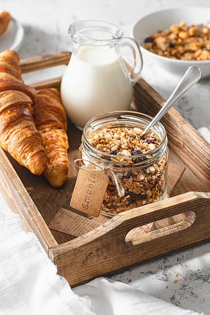 Homemade granola with milk and croissants