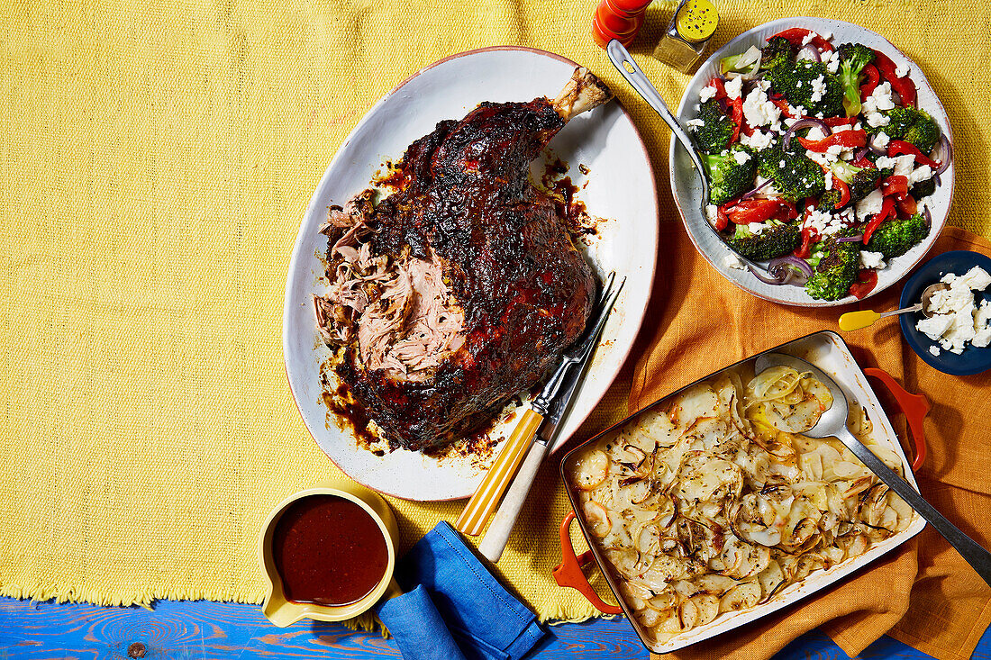 Slow-roast lamb with prunes and roasted garlic, fennel boulangère potatoes, broccoli with red pepper and feta