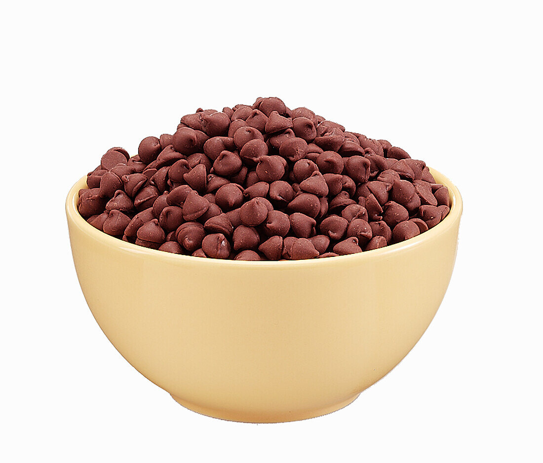 Milk Chocolate baking chips in a yellow ceramic bowl on a white background