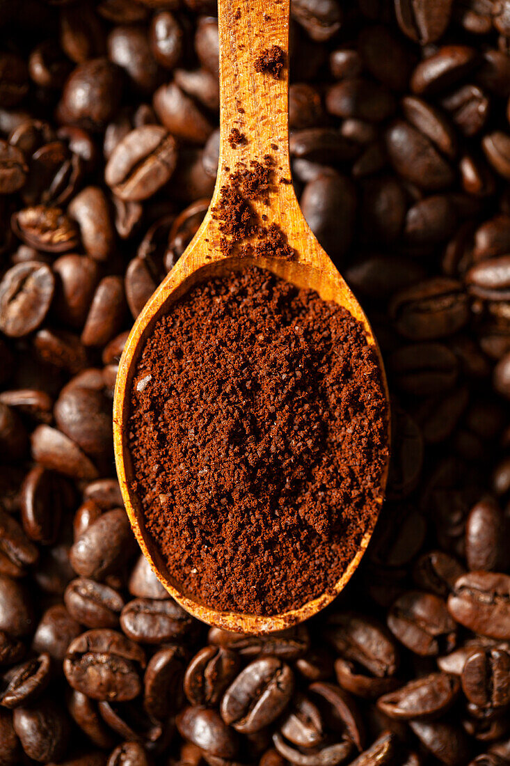 Holzlöffel mit gemahlenem Kaffee auf Kaffeebohnen