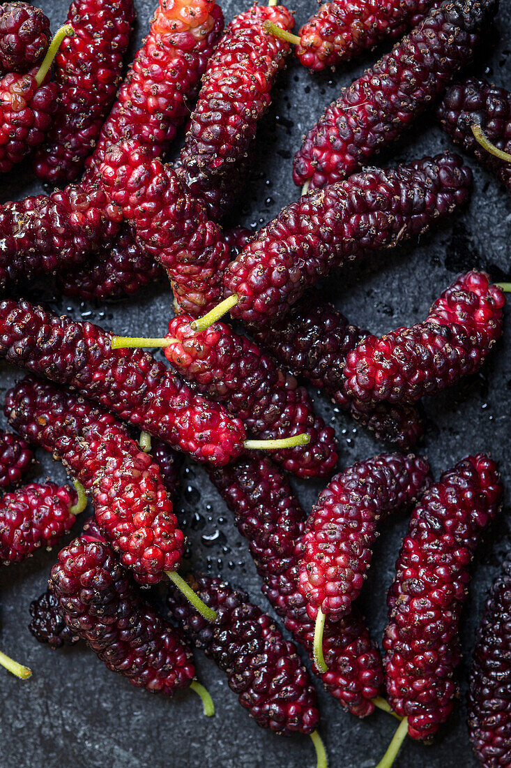 Frische reife Maulbeeren auf dunklem Hintergrund