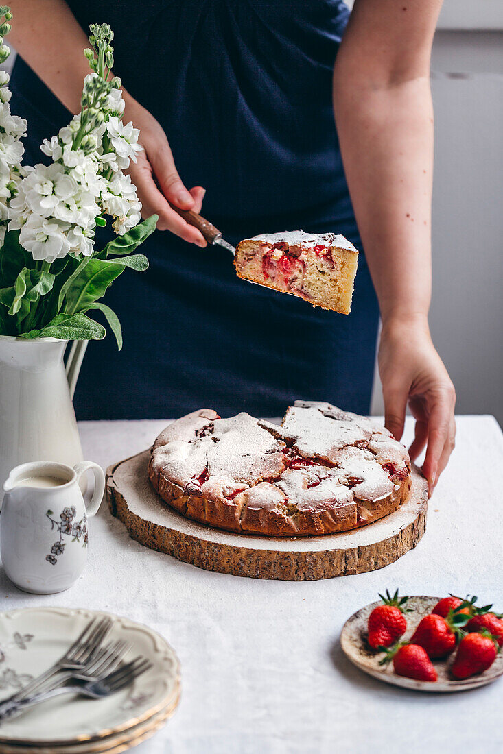 Woman holding a slice of strawberry cake