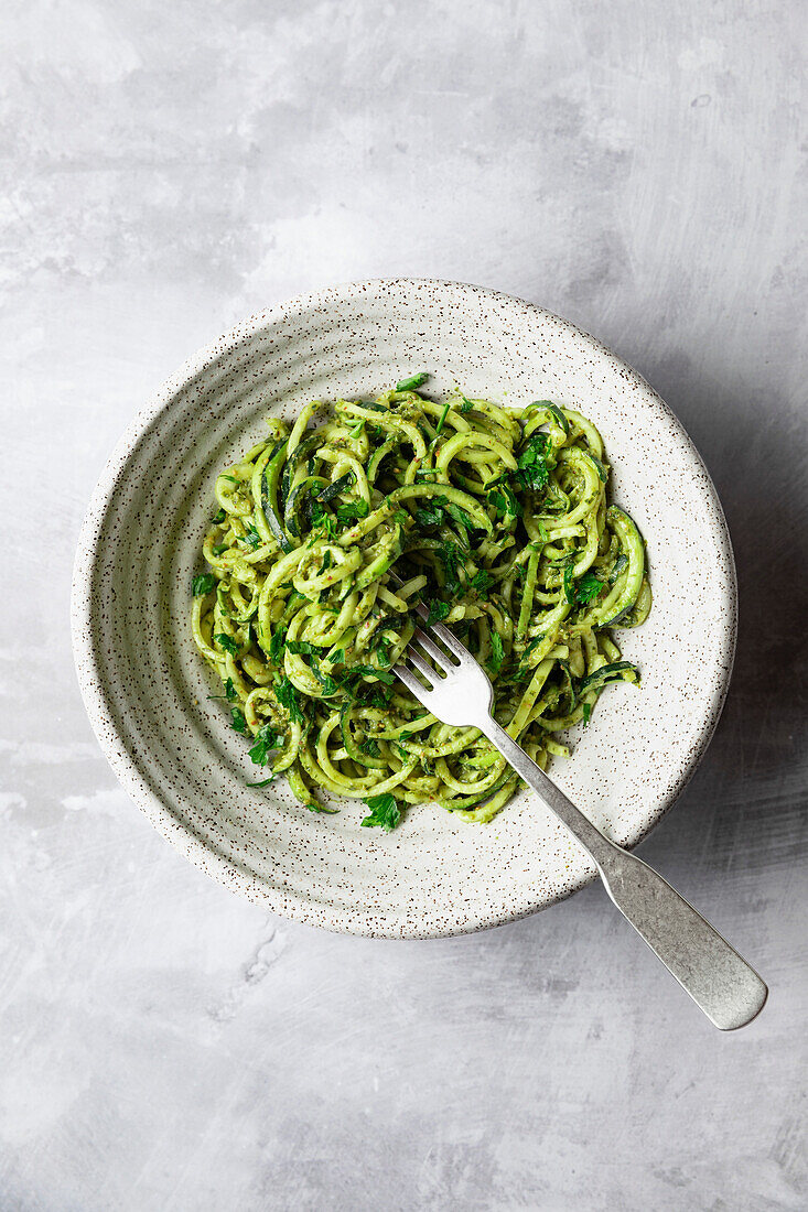 An overhead view of spiralized zucchini noodles with pesto