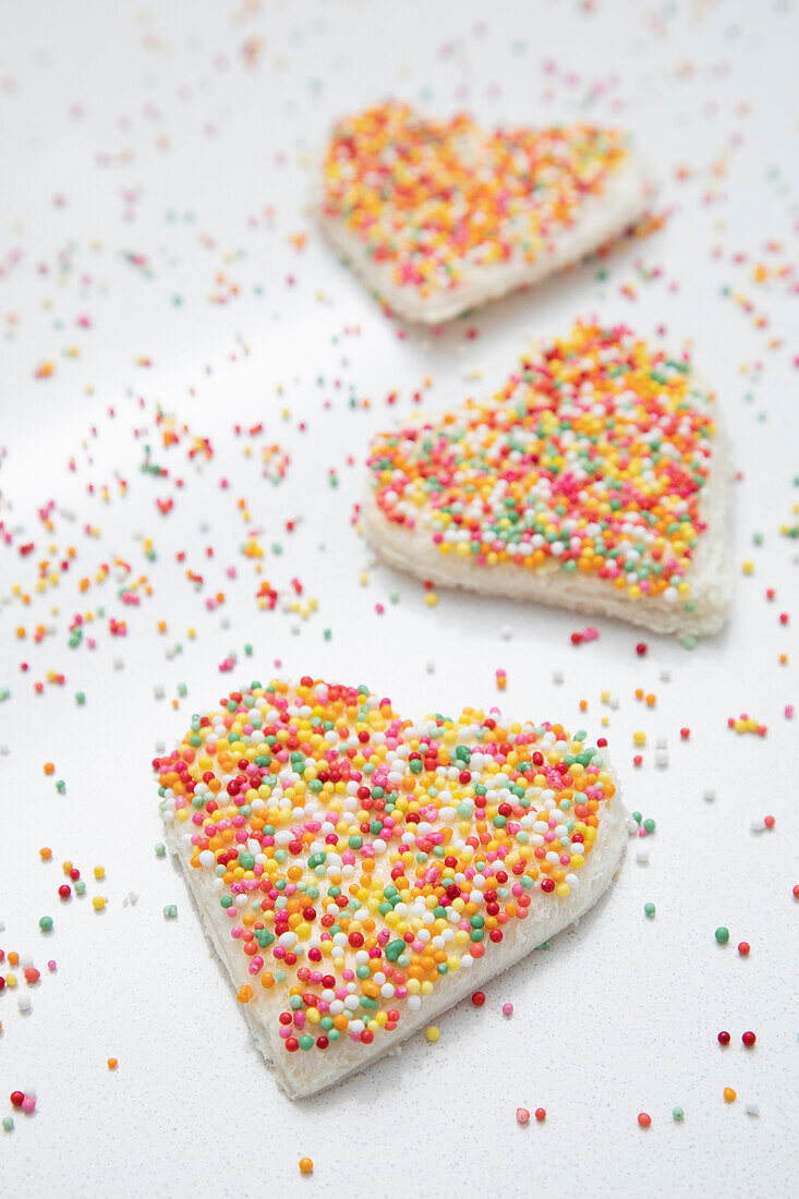 Bunte Zuckerperlen auf herzförmigem Toast