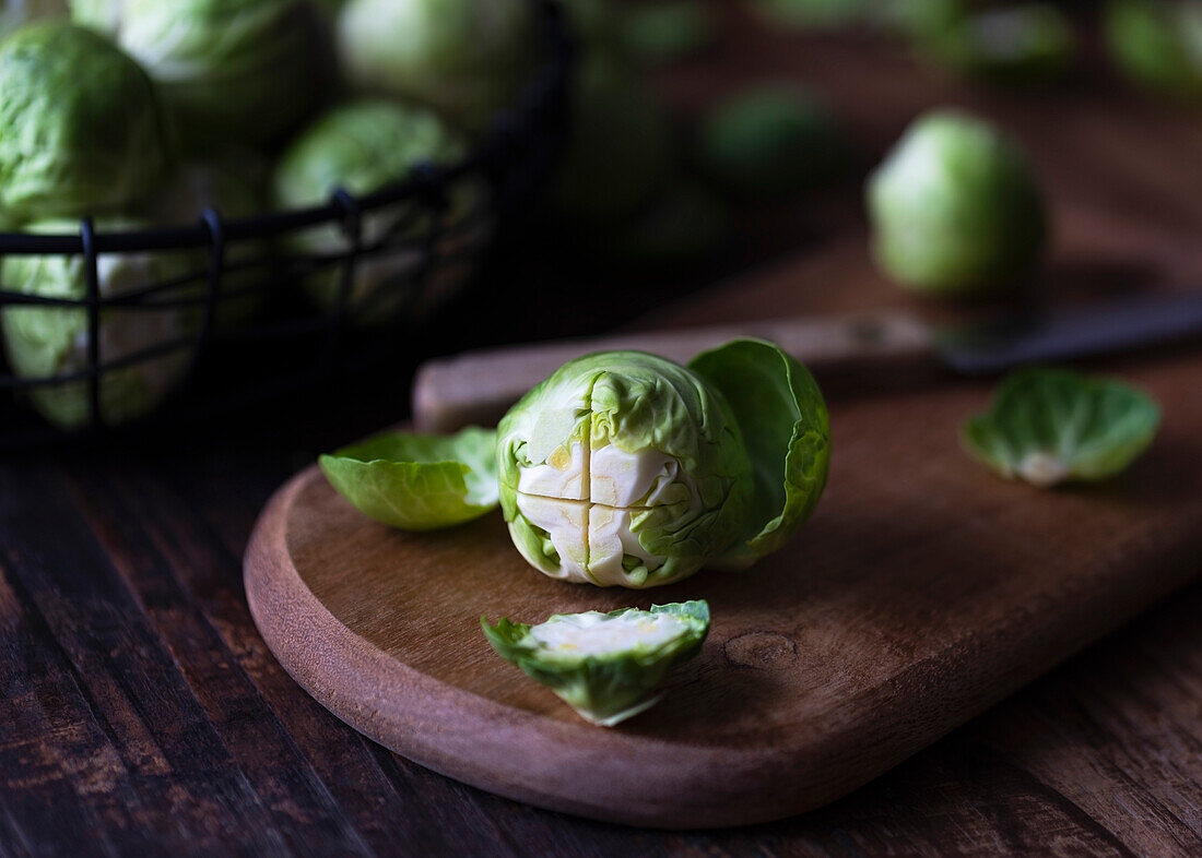 A brussel sprout on a wooden cutting board (Close up)