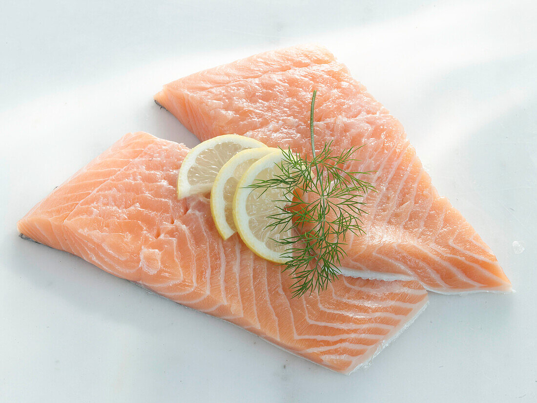 Zwei Scheiben roher Lachs mit Zitrone und Dill