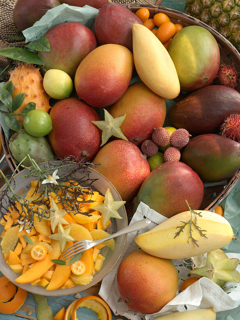 Different kinds of mangos next to a bowl of mango salad