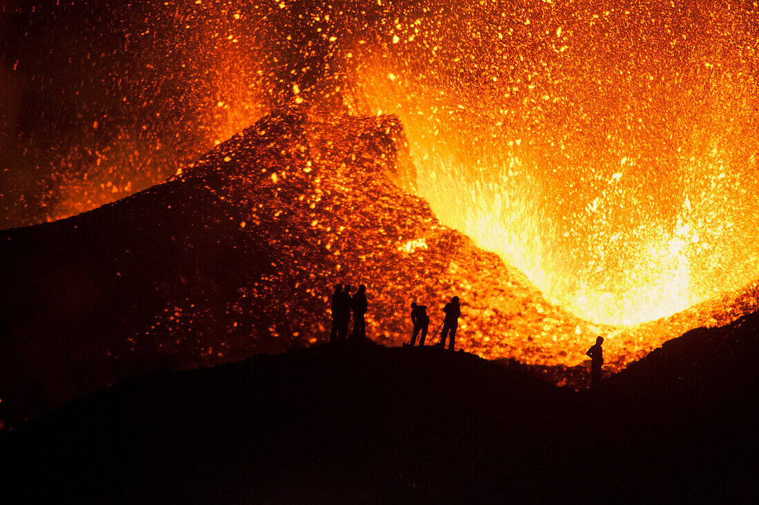 Tourists watching a volcano eruption, Iceland