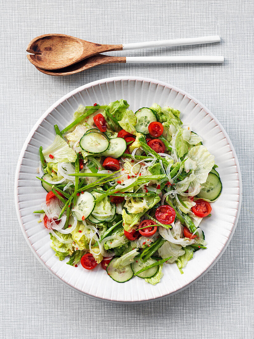 Salad with cucumber, tomatoes, onion, suger snaps and asian dressing