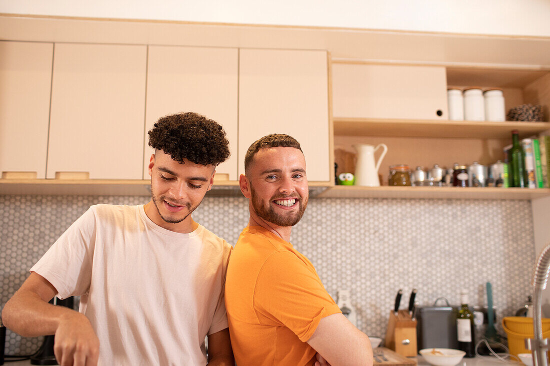 Happy gay male couple in kitchen