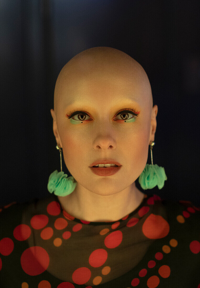 Woman with shaved head and earrings