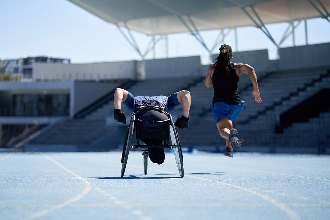 Wheelchair athlete training on sunny blue sports track