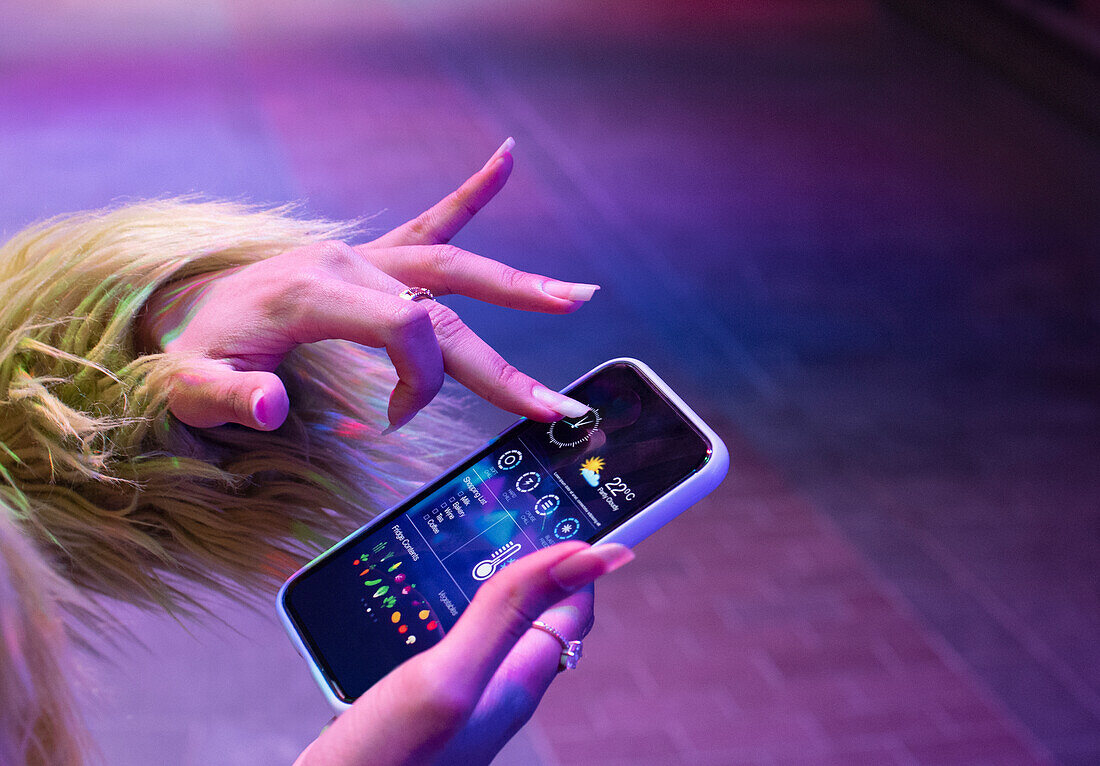 Woman checking home automation app on smart phone screen