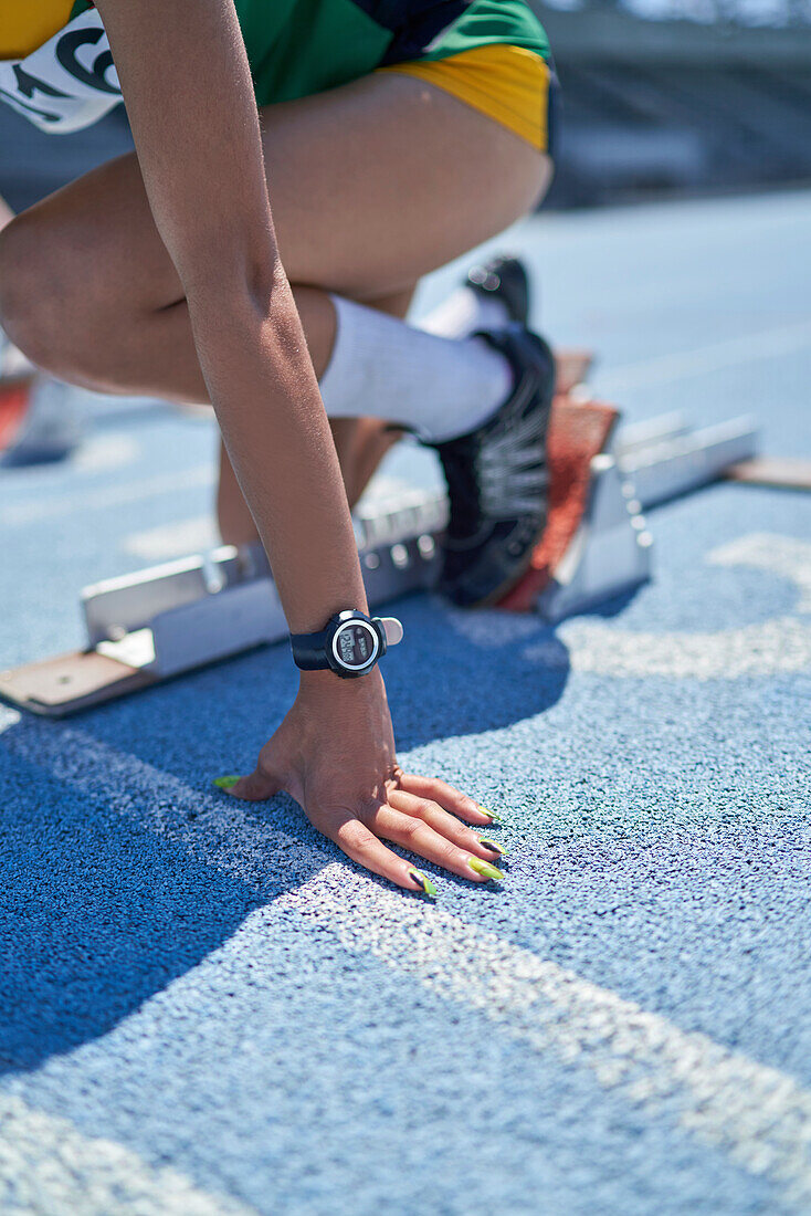 Female track and field athlete at starting block