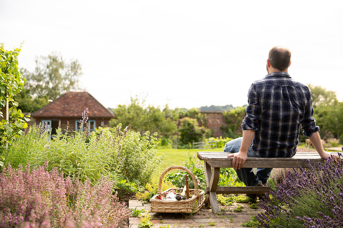 Man taking a break from gardening in sunny cottage garden