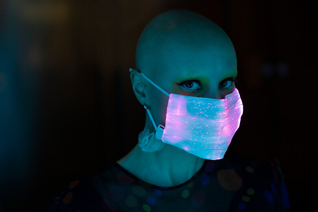 Woman with shaved head in shimmery mask