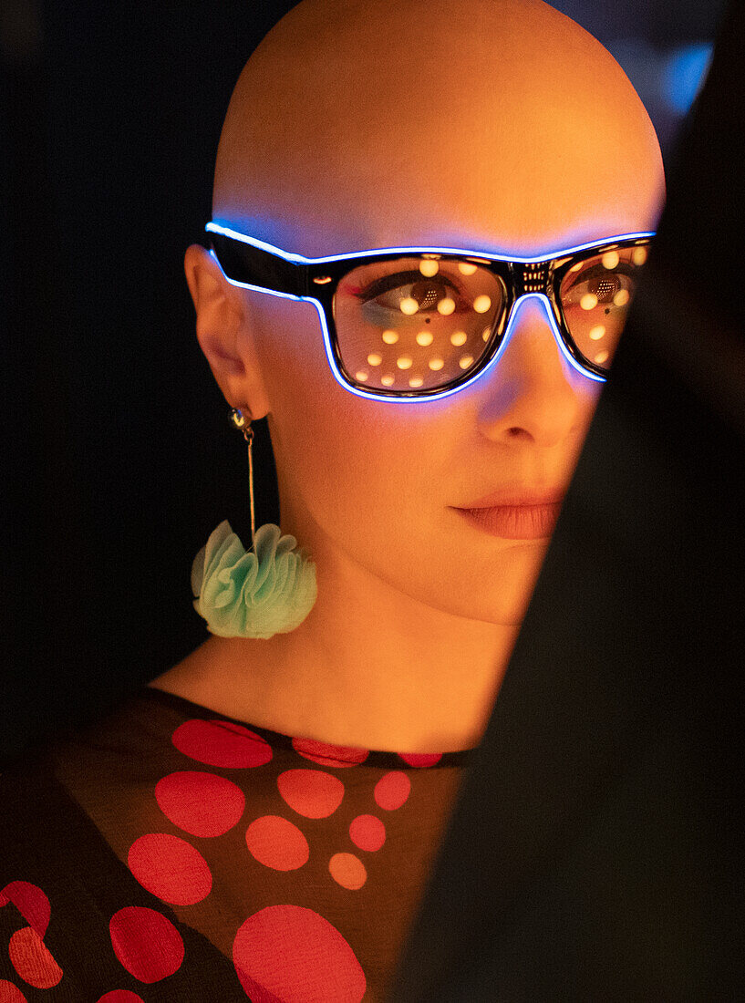 Woman with shaved head in neon eyeglasses